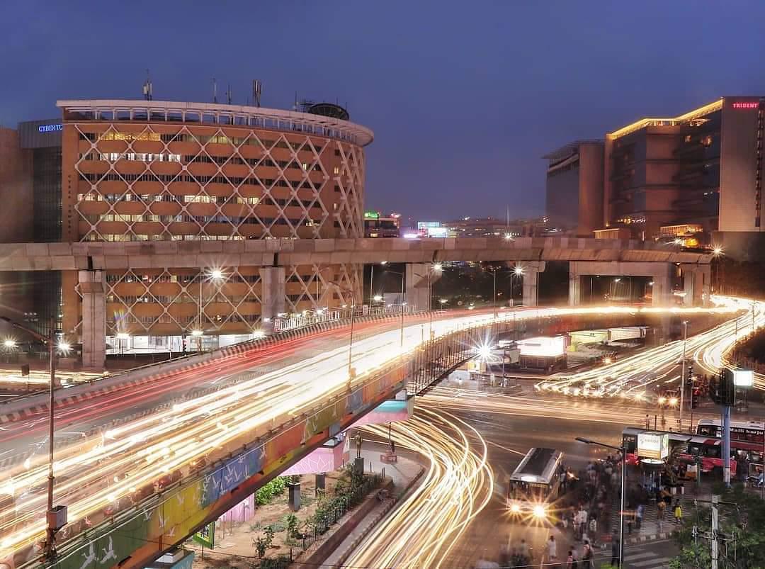 HITEC City and Cyber Towers lit up at dusk, with light-trail traffic below